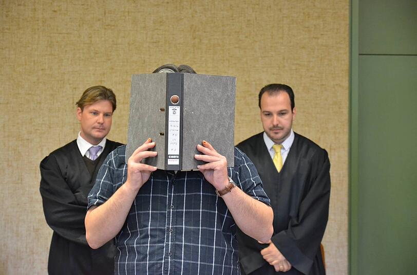 Ibil B. (38) versteckt sein Gesicht hinter einem Aktenordner. Hinter ihm die Anwälte Nicolas Frühsorger (r.) und Michael Weiss.Er muss sechs Jahre und drei Monate in Haft.