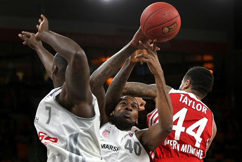 Bayerns Bryce Taylor im Kampf um den Ball - gegen Bambergs Rakim Sanders und D'or Fischer.