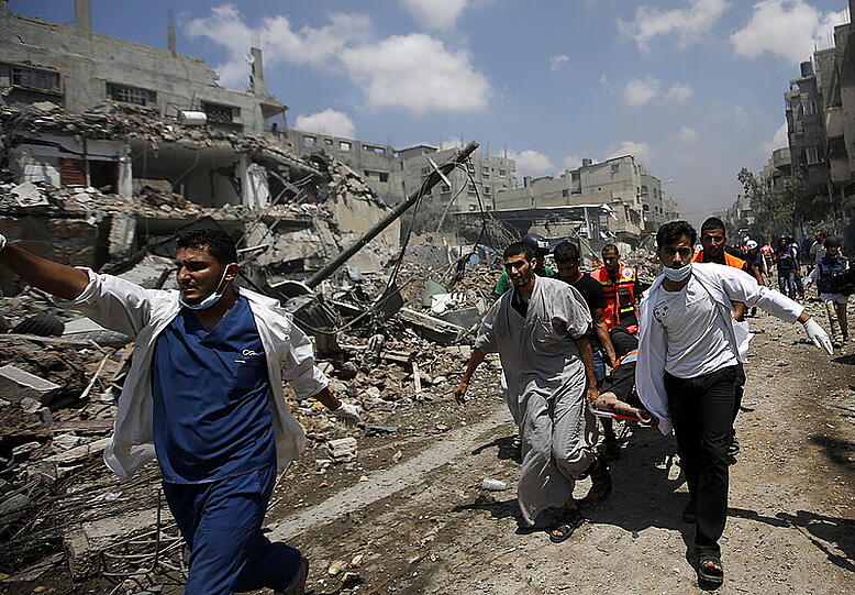 Palästinenser bringen einen Verletzten in Sicherheit. Im Gazastreifen geht die blutige Bodenoffensive israelischer Truppen weiter.