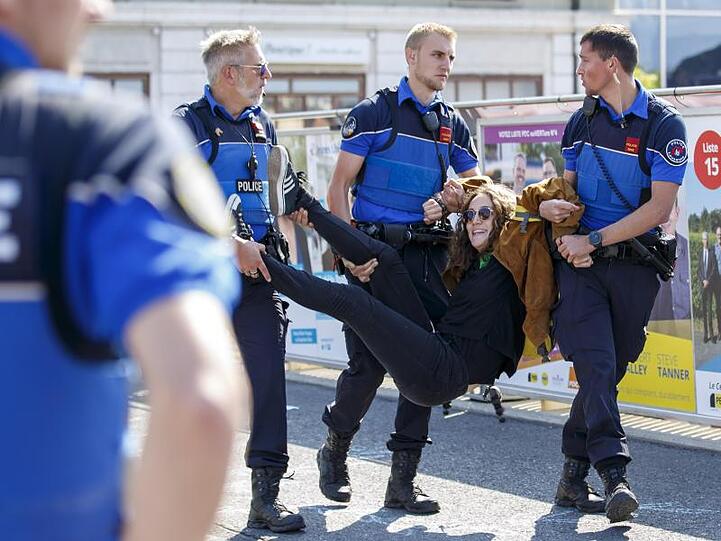 Abgasfrei zum Polizeiwagen: Eine Demonstrantin wird in Lausanne weggetragen.