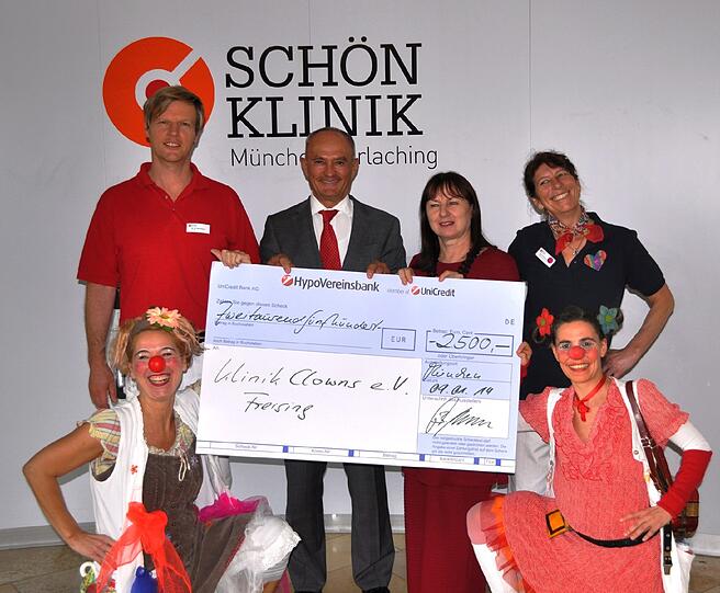 Spendenübergabe der JBH-Personalberatung Herget in der Schön Klinik München Harlaching (v. l.): Dr. Michael Poschmann, Jürgen B. Herget, Elisabeth Makepeace (Vorsitzende KlinikClowns e.V.), Karin Kinzelmann Heilerziehungspflegerin), davor die KlinikClowns &bdquo;Dr. Uuups&ldquo; (l.) und &bdquo;Dr. Gurki Klumps&ldquo;.