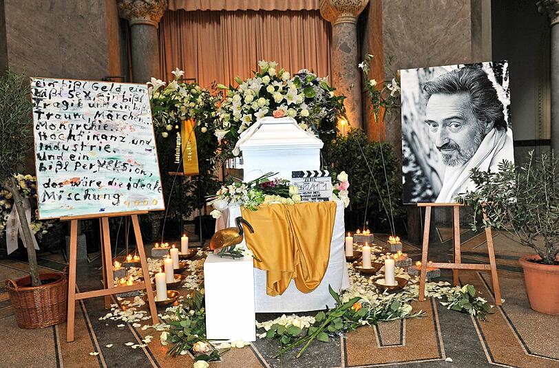 Von 10.00 bis 14.00 Uhr soll in der Aussegnungshalle des Nordfriedhofes ein Kondolenzbuch neben dem mit Blumen geschmückten Sarg des Filmemachers ausliegen.