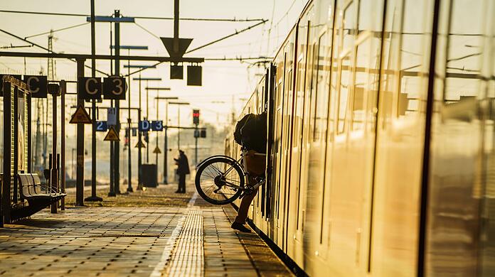 Ein Fahrgast steigt mit seinem Rad in eine S-Bahn.
