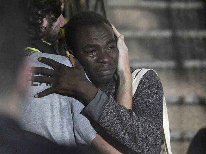 Ein Mann umarmt weinend ein Besatzungsmitglied, nachdem auf Lampedusa angekommen ist.
