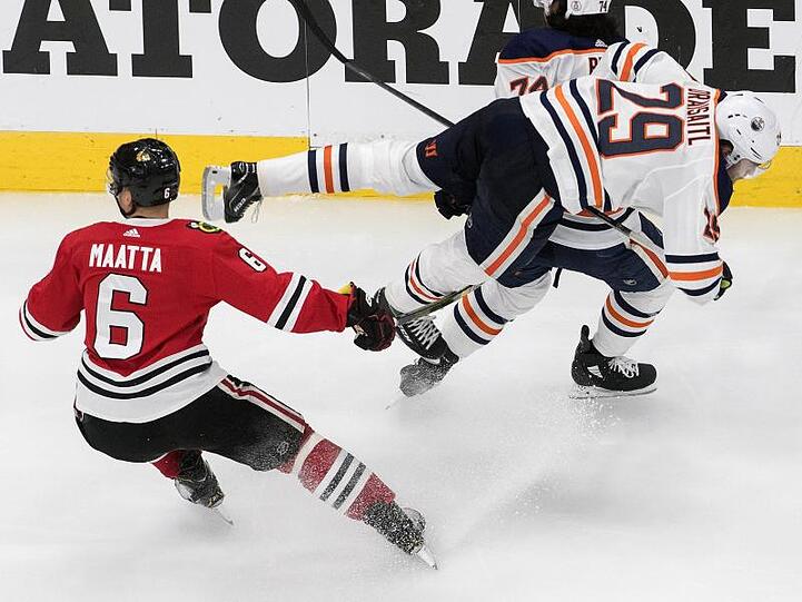 Edmontons Leon Draisaitl (r) wird durch Olli Maatta von den Chicago Blackhawks zu Fall gebracht.