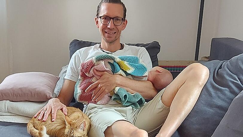Kai Pietzner mit seinem neugeborenen Sohn und Kater Felix.