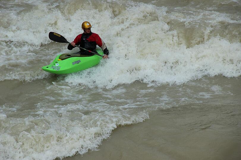 Hochwasser für die einen, perfekte Wellen für die anderen. Waghalsig tummeln sich Sportler in der Isar.