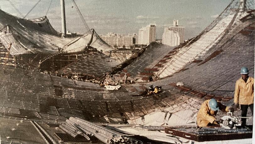 Arbeiter setzen das Zeltdach im Münchner Olympiastadion zusammen: Es symbolisiert Aufbruch. Die transparente Konstruktion steht in engem Kontakt mit der Umgebung.