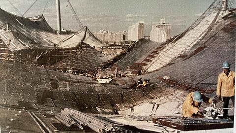Arbeiter setzen das Zeltdach im Münchner Olympiastadion zusammen: Es symbolisiert Aufbruch. Die transparente Konstruktion steht in engem Kontakt mit der Umgebung.