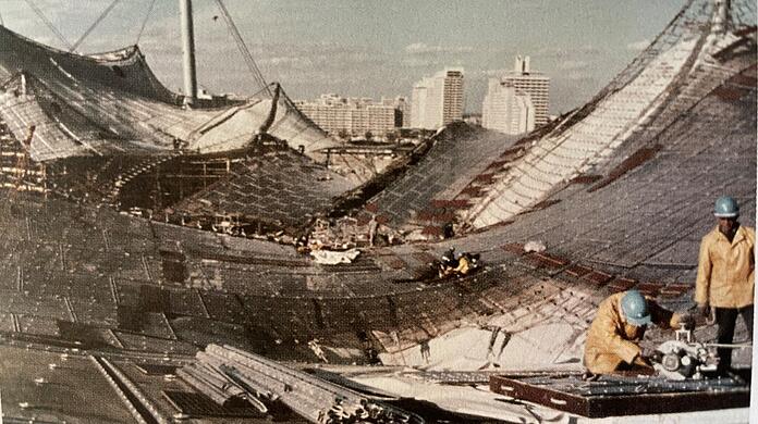 Arbeiter setzen das Zeltdach im Münchner Olympiastadion zusammen: Es symbolisiert Aufbruch. Die transparente Konstruktion steht in engem Kontakt mit der Umgebung.
