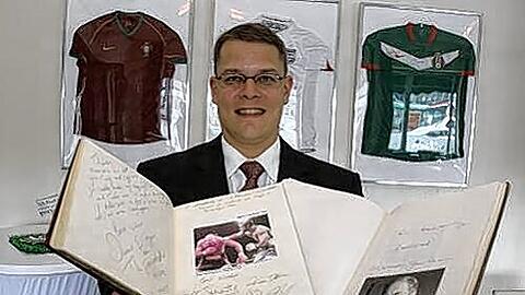 Direktor Georg Bailer zeigt die Alben mit den Grüßen Prominenter.