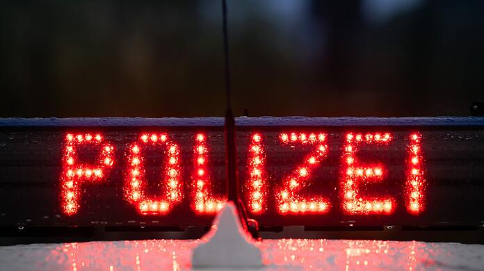 Der Schriftzug „Polizei“ auf einem Streifenwagen.