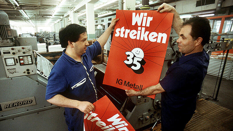 Drucker in der gewerkschaftseigenen Union-Druckerei in Frankurt am Main halten am 27.04.1984 in ihren Händen Streikplakate, mit denen die IG Metall die Einführung der 35-Stunden-Woche fordert. Es war einer der härtesten Arbeitskämpfe in der Bundesrepublik und sollte in der Folge die Arbeitswelt komplett umkrempeln. Drucker in der gewerkschaftseigenen Union-Druckerei in Frankurt am Main halten am 27.04.1984 in ihren Händen Streikplakate, mit denen die IG Metall die Einführung der 35-Stunden-Woche fordert. Es war einer der härtesten Arbeitskämpfe in der Bundesrepublik und sollte in der Folge die Arbeitswelt komplett umkrempeln.