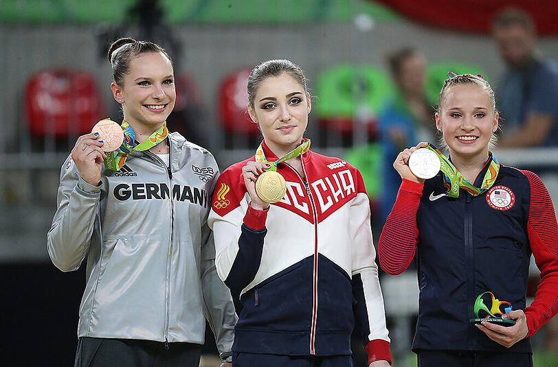 Turnerin Sophie Scheder (l) freut sich über Bronze am Stufenbarren.