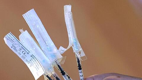 Ein Notfallsanitäter hält vorbereitete Spritzen mit dem Pfizer-Biontech Covid-19 Impfstoff in der Hand.