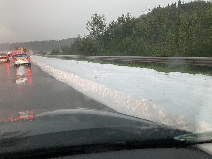 Eine dicke Schicht mit Hagelkörnern liegt auf dem Randstreifen der Autobahn 8.