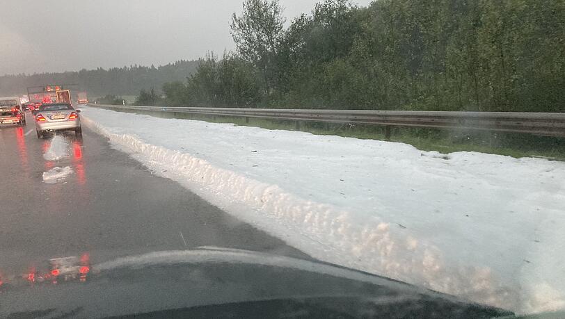 Eine dicke Schicht mit Hagelkörnern liegt auf dem Randstreifen der Autobahn 8. Eine dicke Schicht mit Hagelkörnern liegt auf dem Randstreifen der Autobahn 8.