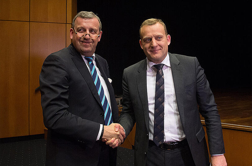 Der Bezirksleiter des IG Metall-Bezirks Baden-Württemberg, Roman Zitzelsberger (r) und der Vorsitzende von Südwestmetall, Stefan Wolf reichen sich in Böblingen die Hand. Foto: Marijan Murat