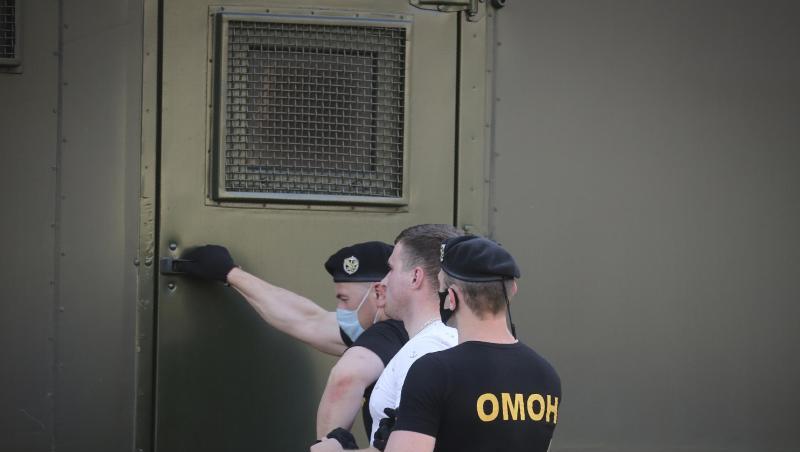Polizeibeamte mit Mundschutzmasken halten während einer Kundgebung in Minsk einen Demonstranten fest. Polizeibeamte mit Mundschutzmasken halten während einer Kundgebung in Minsk einen Demonstranten fest.