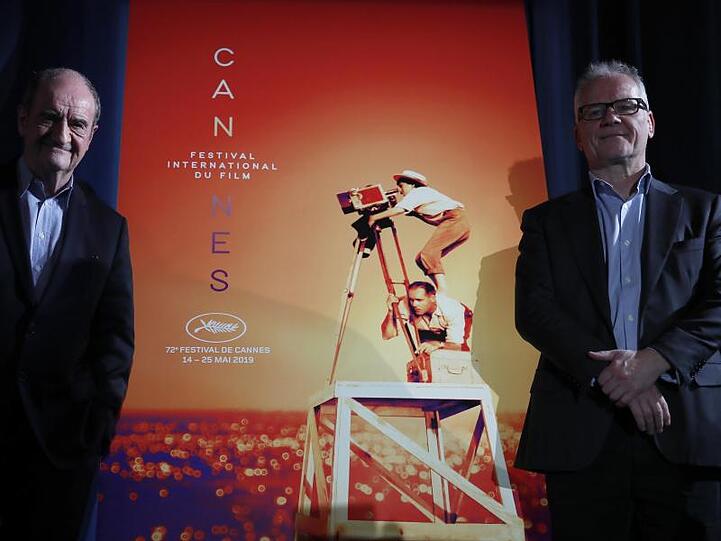 Festivaldirektor Thierry Frémaux (r) und Festivalpräsident Pierre Lescure vor dem offiziellen Cannes-Plakat, das die verstorbene Regisseurin Agnes Varda zeigt.