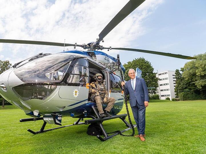 Innenminister Joachim Herrmann (CSU) steht neben einem der neuen Hubschrauber. Foto: Peter Kneffel/dpa