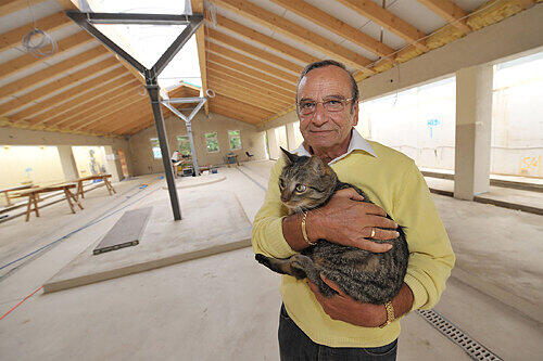 Denny Baruch mit Gismo. Der Kater könnte auch ins neue Katzenhaus im Hintergrund einziehen &ndash; wenn er nicht vorher ein Zuhause findet.