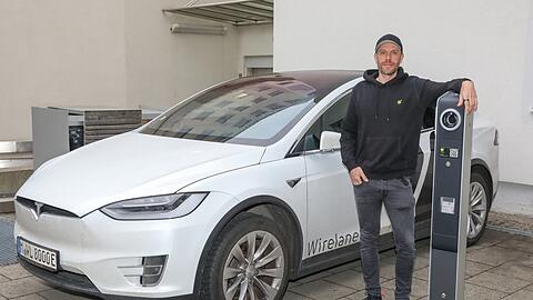 Constantin Schwaab in seiner Wirelane-Firmenzentrale an der Von-der-Tann-Straße 12. Er steht neben seiner firmeneigenen Ladesäule. Seine Mitarbeiter fahren zwar noch weiterhin Tesla, er selbst jedoch nicht mehr.