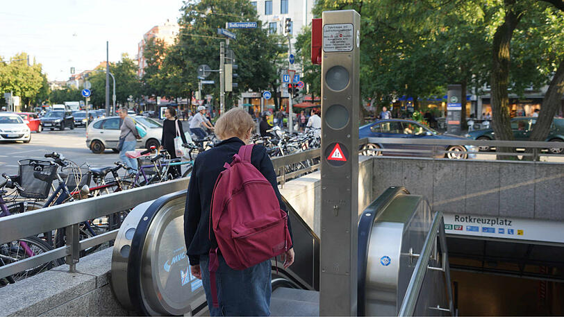 Eine Frau wartet am Rotkreuzplatz darauf, dass die Richtung der Rolltreppe wechselt.