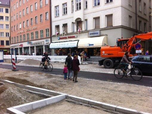 Fußgänger zwischen den Bauzäunen die Straße querten.