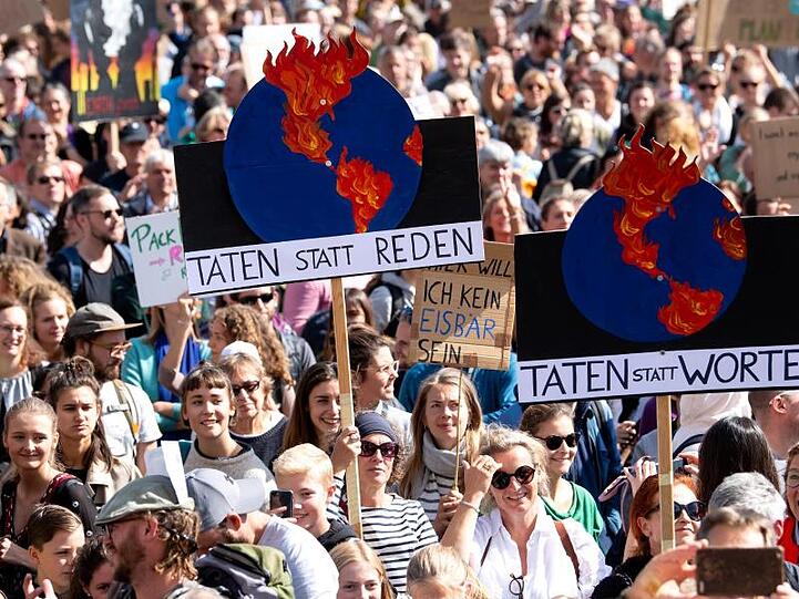 Teilnehmer einer Demonstration in München tragen Transparente mit sich. Foto: Sven Hoppe