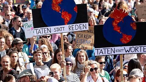 Teilnehmer einer Demonstration in München tragen Transparente mit sich. Foto: Sven Hoppe