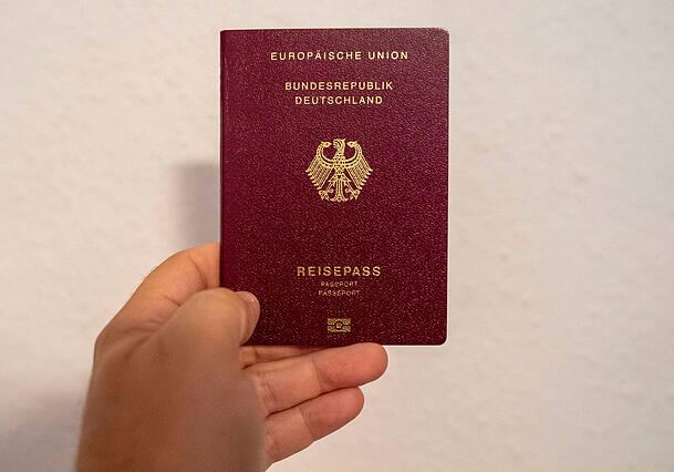 Eine Person zeigt ihren deutschen Reisepass. Eine Person zeigt ihren deutschen Reisepass.