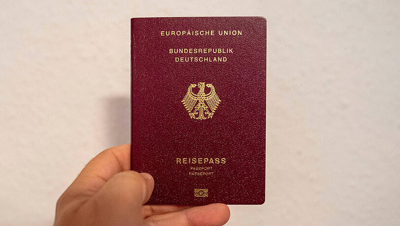 Eine Person zeigt ihren deutschen Reisepass. Eine Person zeigt ihren deutschen Reisepass.