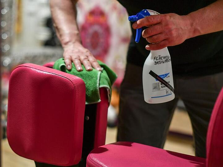 Ein Mitarbeiter eines Fitnessstudios reinigt die Geräte. Foto: Jens Kalaene/dpa-Zentralbild/dpa/Symbolbild