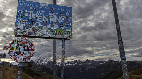Fu&szlig;ballfans haben ein Stra&szlig;enschild am Sellajoch in den Dolomiten mit Aufklebern verunziert. Zu viele Touristen belasten die Region zusehends.