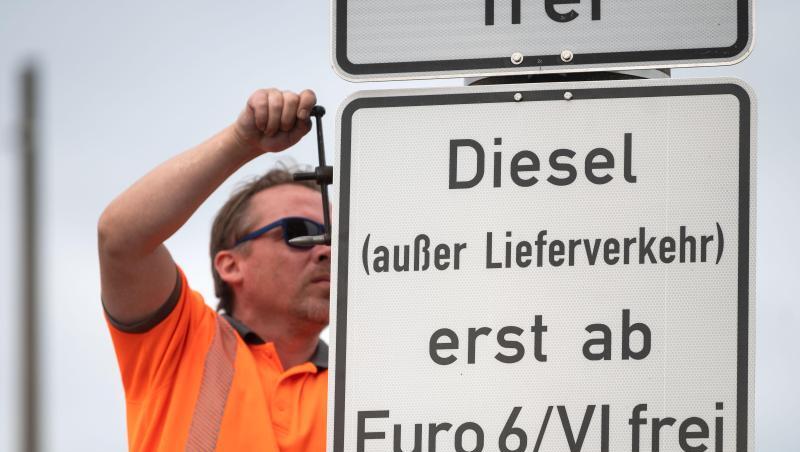 Ein Arbeiter hängt ein Schild auf, das auf ein Fahrverbot für Dieselfahrzeuge der Euronorm 5/V und schlechter hinweist. Ein Arbeiter hängt ein Schild auf, das auf ein Fahrverbot für Dieselfahrzeuge der Euronorm 5/V und schlechter hinweist.