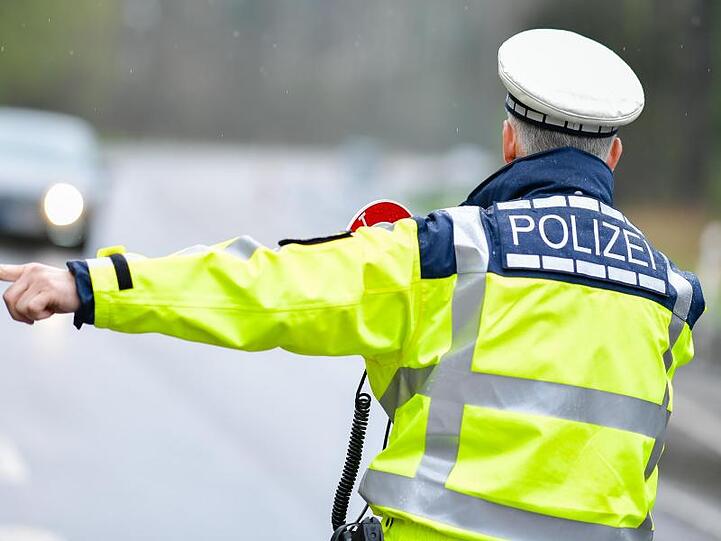 Ein Polizist bei einer Geschwindigkeitskontrolle an einer Bundesstraße.