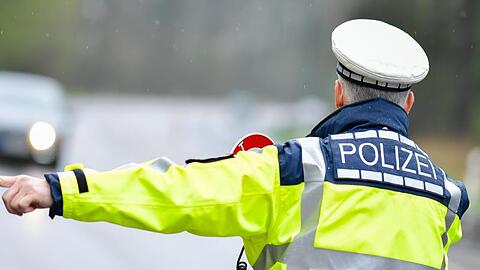 Ein Polizist bei einer Geschwindigkeitskontrolle an einer Bundesstraße.