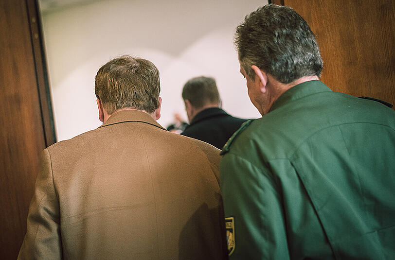 Der angeklagte Ex-Manager der Textilkette NKD (l) wird am 28.04.2015 in Hof (Bayern) von Polizisten zum Gerichtssaal begleitet. Im Prozess um angebliche Entführungs- und Mordpläne gegen einen Hofer Richter wird am 15.07.2015 das Urteil erwartet.