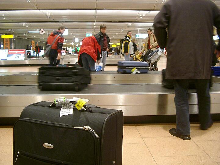 Eine weiße Papierschlaufe, der Baggage Tag, bestimmt, wohin und mit welchem Flieger der Koffer reist.
