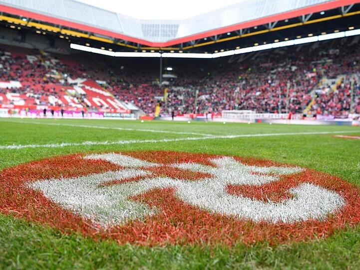 Ein Logo des 1. FC Kaiserslautern ist auf Spielfeld vor der Tribüne zu sehen. Foto: Uwe Anspach/Archivbild