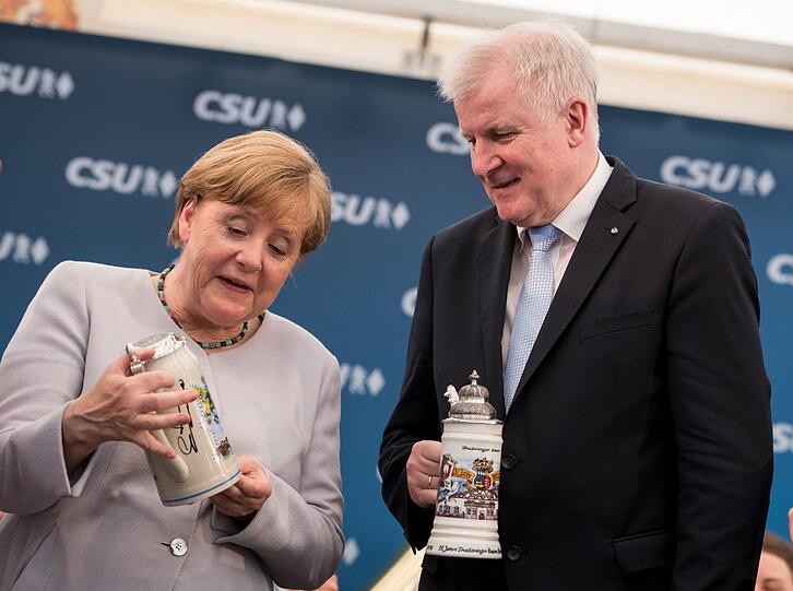 Als Geschenk für Merkel und Seehofer gibt&rsquo;s Bierkrüge vom Veranstalter &ndash; damit sie sich aus der Fernse zuprosten können.