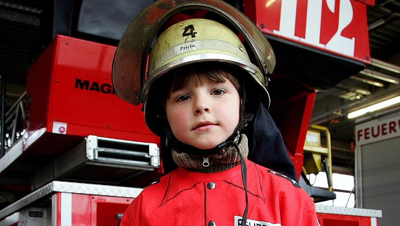 Ein kleiner Bub schlüpft schon mal in die richtige Kleidung. Mit vielen Aktionen werben Feuerwehren in Bayern um Nachwuchs. Ein kleiner Bub schlüpft schon mal in die richtige Kleidung. Mit vielen Aktionen werben Feuerwehren in Bayern um Nachwuchs.