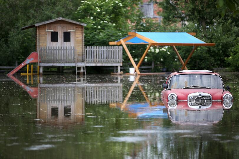 Ein Oldtimer steht am 11.06.2013 auf einem überfluteten Grundstück im vom Hochwasser eingeschlossenen Schönhausen (Sachsen-Anhalt).