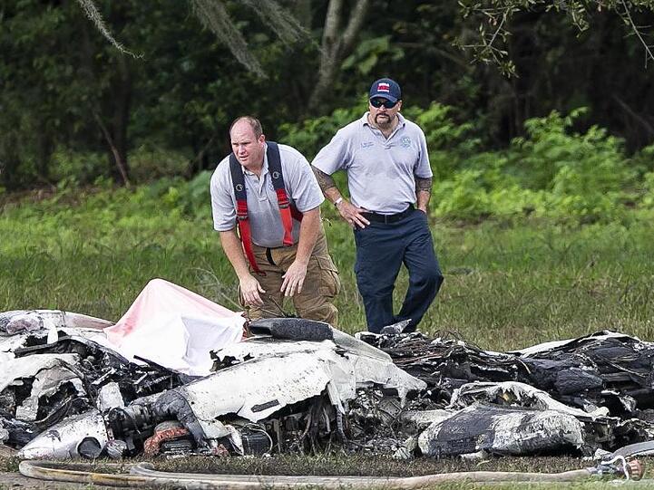 Rettungskräfte stehen neben dem abgestürzten Flugzeug in Ocala.