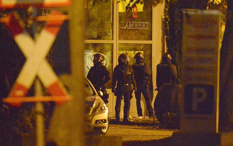 Mit erhobenen Händen kommt ein Mann auf die SEK-Beamten zu, im Hintergrund lauern Heckenschützen der Polizei. Die Beamten nehmen den Mann fest, es ist aber nicht der Täter, der sich in einem Imbiss in Freiburg veschanzt hat.