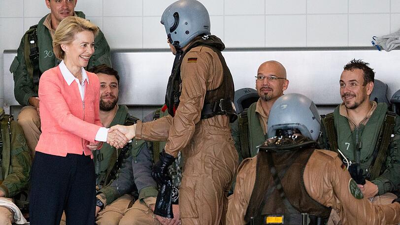 Ursula von der Leyen (CDU), Verteidigungsministerin, steht bei ihrem Besuch der Marineoperationsschule an einem Schwimmbecken und begrüßt die Rettungsschwimmer der Marine.