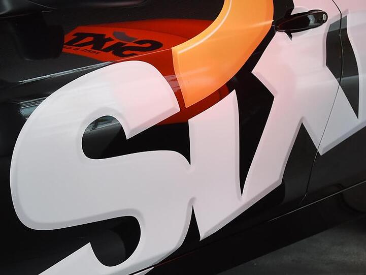 Das Logo des Autovermieters Sixt SE an einer Autotür. Foto: Tobias Hase/dpa/Archivbild
