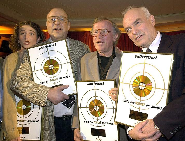 Die Schauspieler Manfred Krug (2.vl) und Charles Brauer (r) zeigen am Dienstagabend (10.04.2001) zusammen mit Fanny Krug (l, Tochter von Manfred Krug) und dem Komponisten Klaus Doldinger (2.vr) ihre Goldenen Schallplatten, die ihnen für das Album "Tatort - die Songs" in Hamburg verliehen wurde. Die Platte wurde bisher 150 000 Mal verkauft.