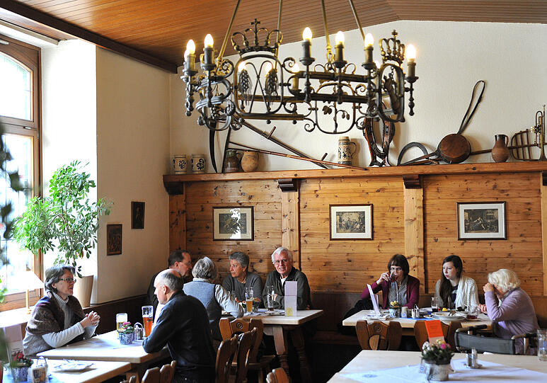 Unter eisernen Kerzenleuchtern prosten sich im &bdquo;Weißen Bräuhaus&ldquo; mehrere Generationen zu und genießen die Leberknödelsuppe.